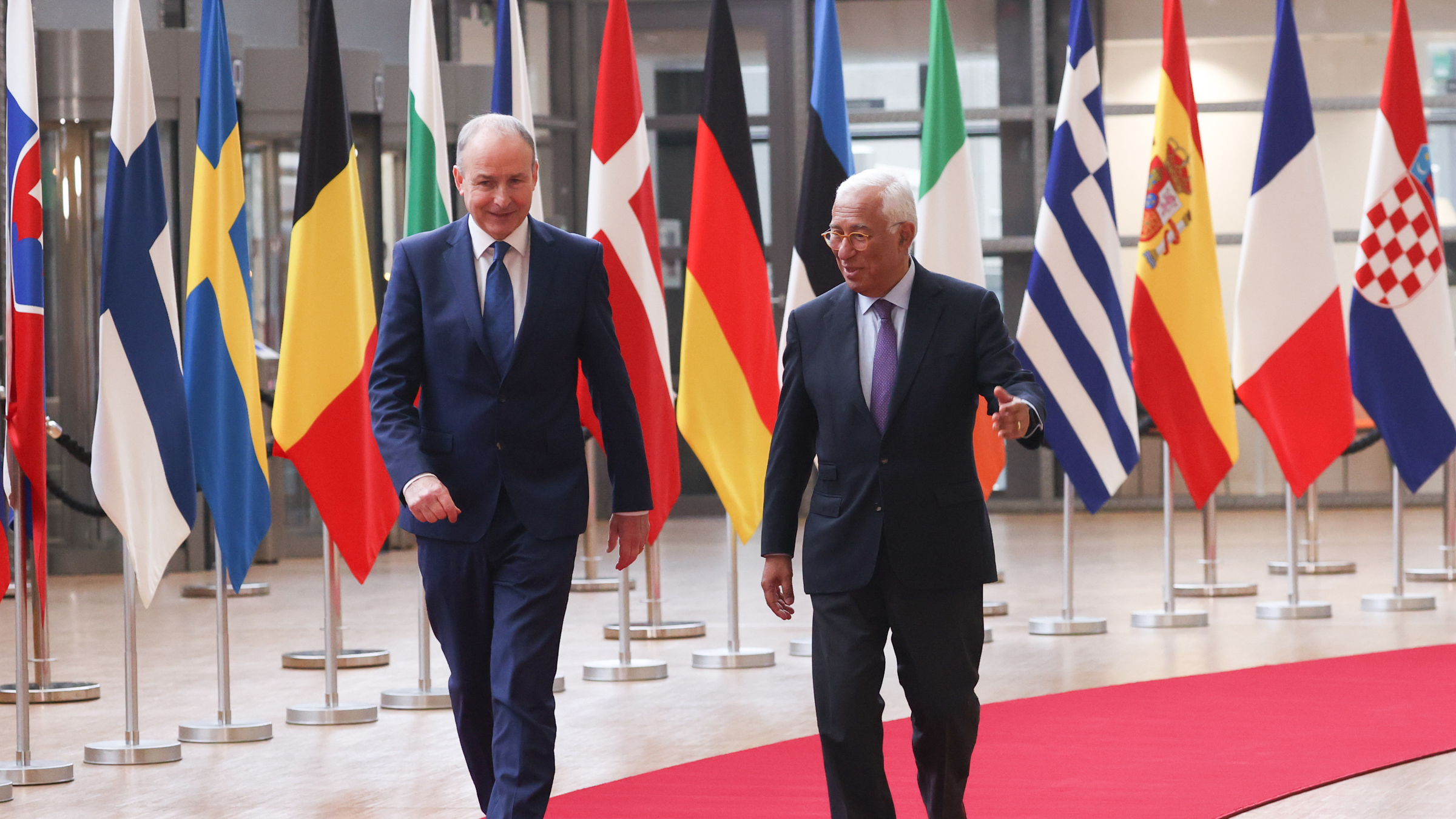 Two men walking on a red carpet
