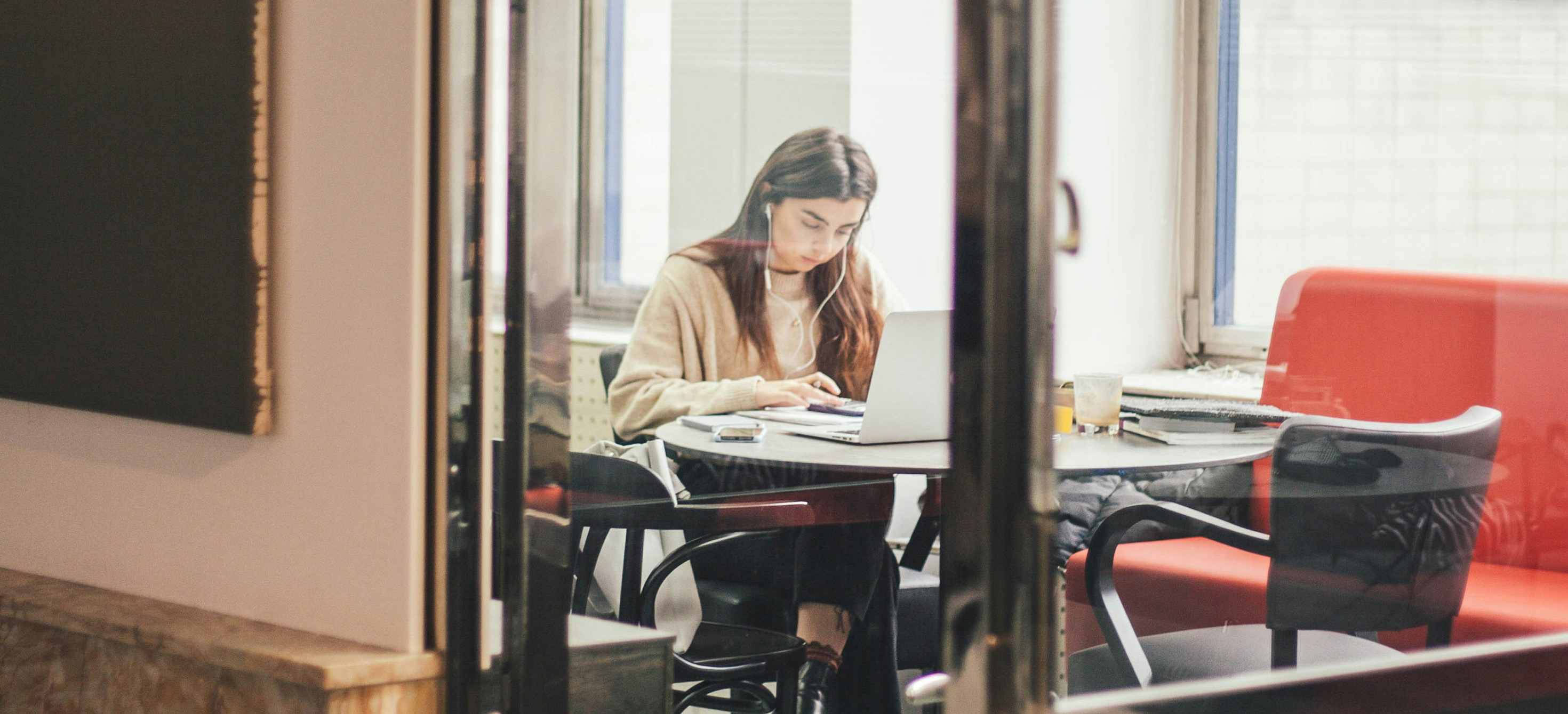 Woman sitting and using laptop indoors