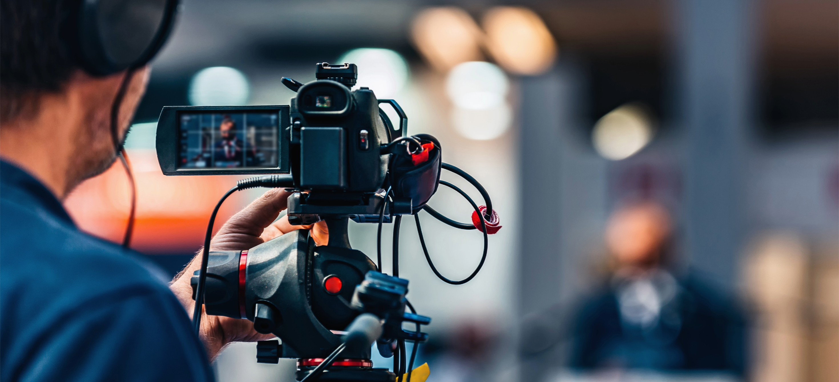 Image of a man recording with a video camera.