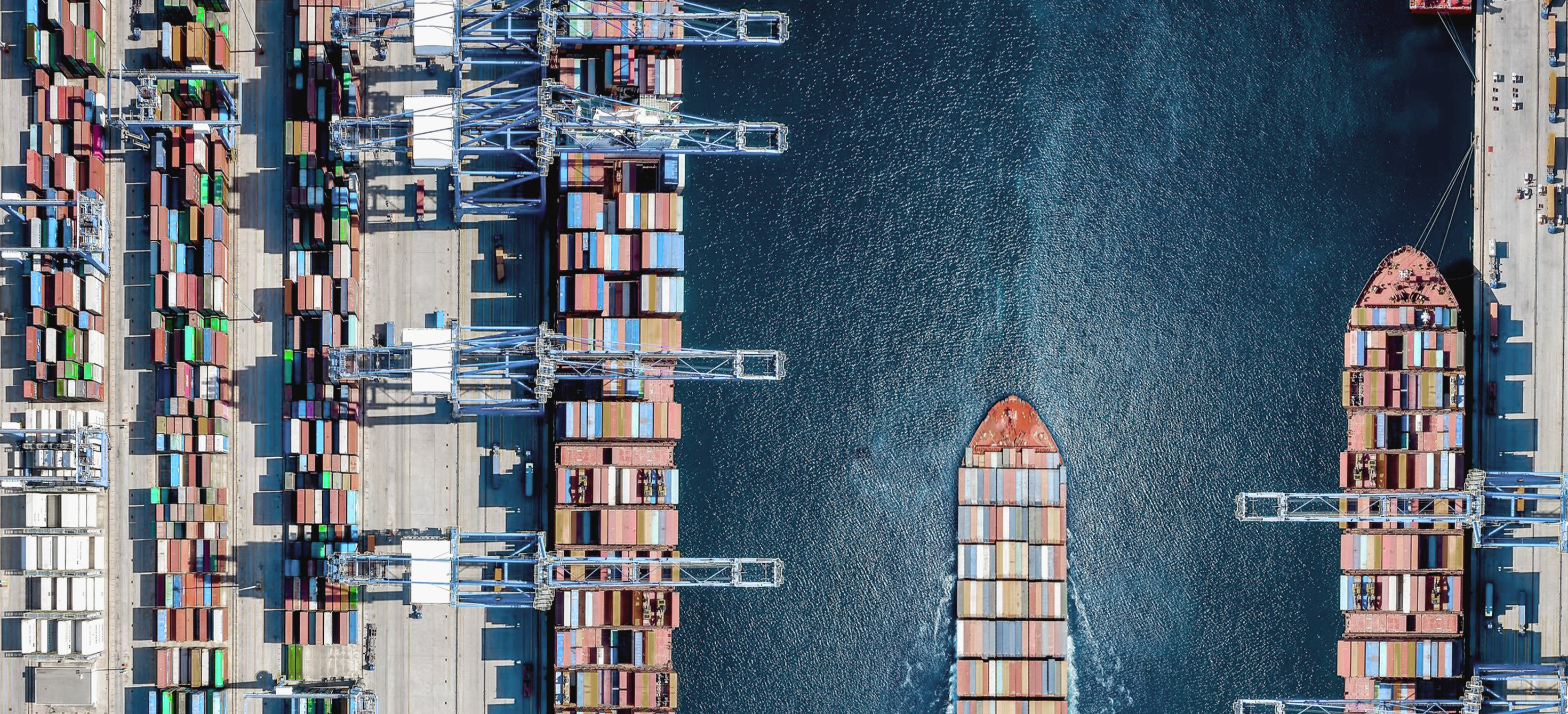 Vue aérienne d'un grand terminal de navires porte-conteneurs avec activité de chargement et trafic maritime