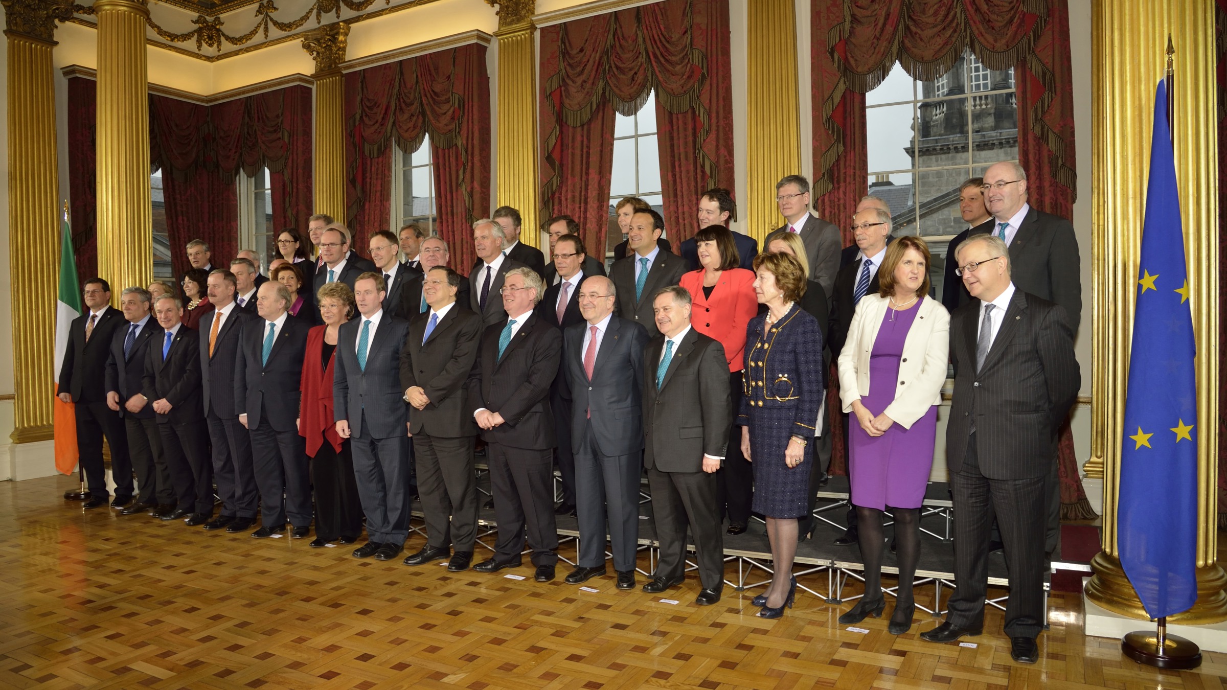 Photo of Irish and European political leaders posing for official photography in ornate room with Irish and European Union flags.