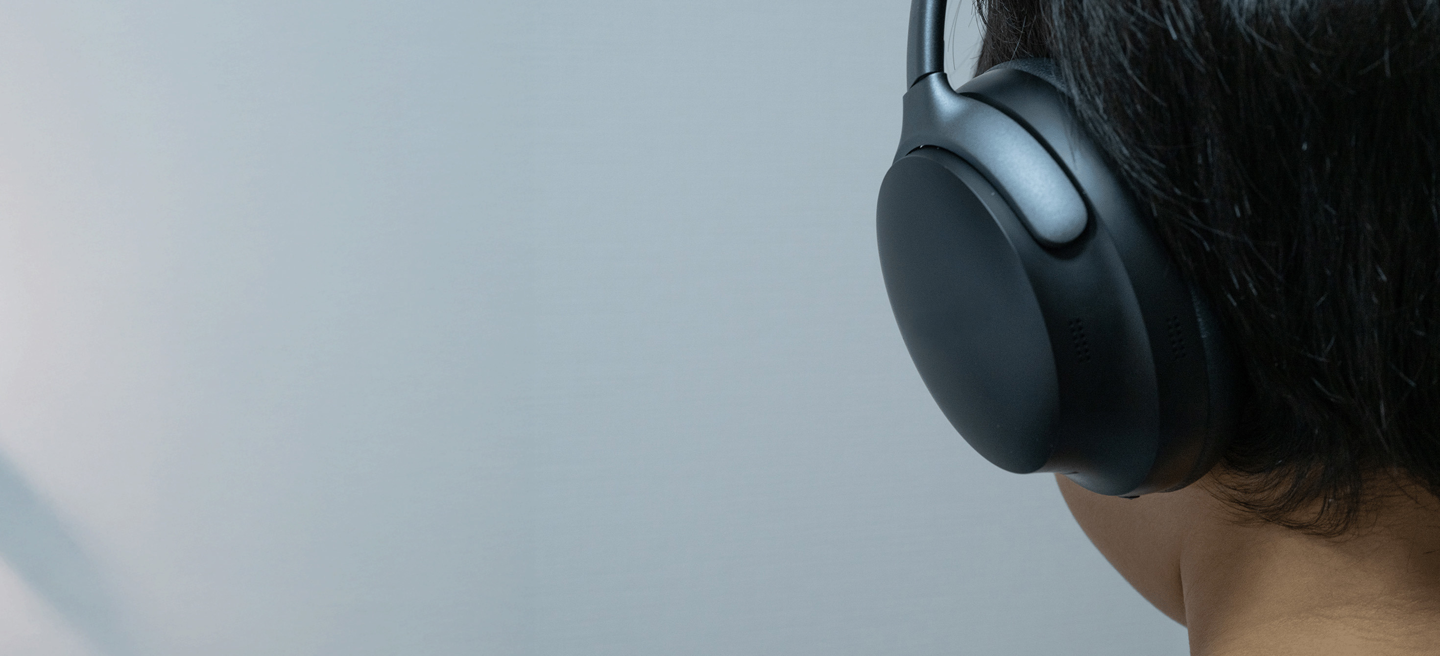 Vue arrière d'une personne portant un casque sans fil noir